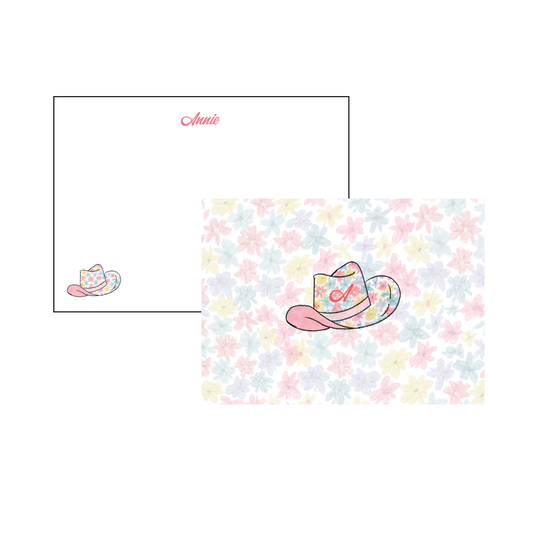 A6 Stationery Set with script font on the front in pink and pink, yellow, purple floral cowgirl hat in the corner. Front has pink, yellow, purple floral design in background with pink, yellow, purple floral cowgirl hat with initial. Name and initial personalized to your liking. 