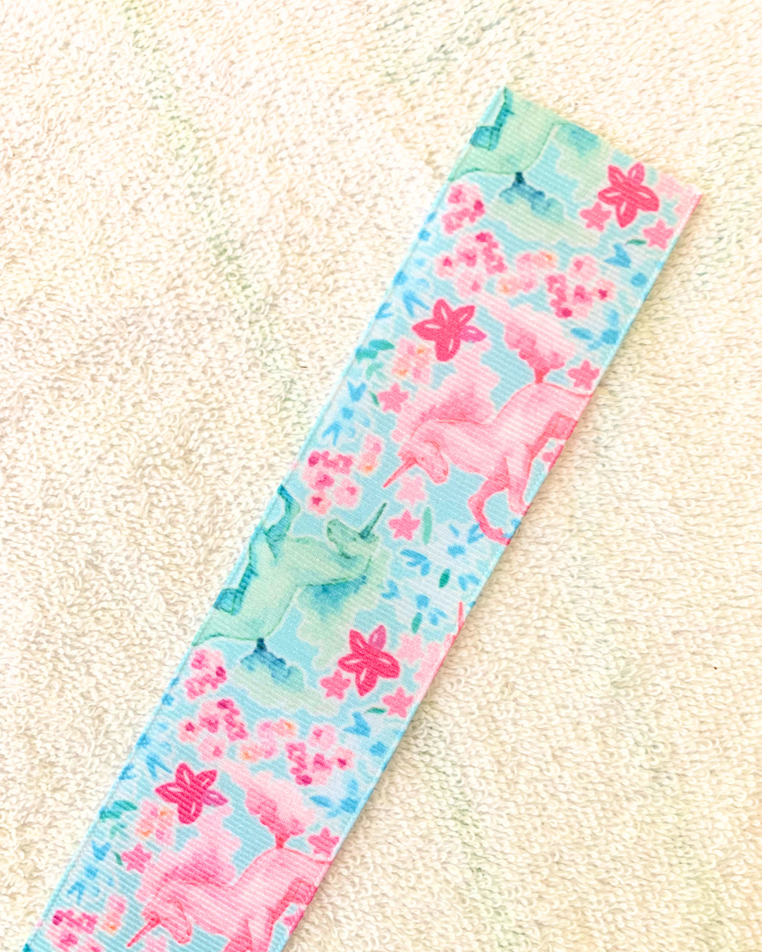 Unicorn design hair ribbon. Unicorn design is pink, green, teal, and blue. 