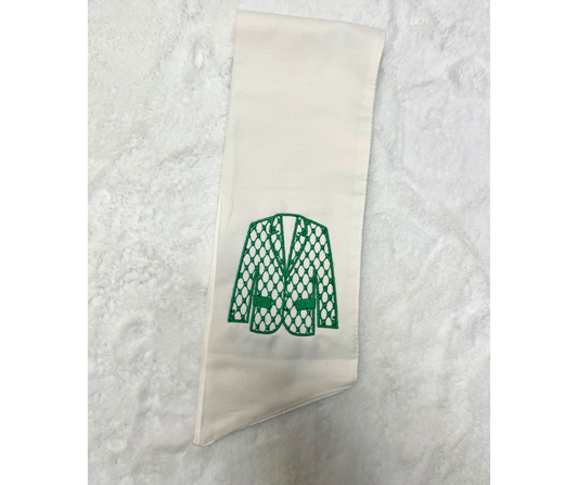 A white sash with a green embroidered jacket/blazer.